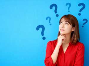 赤いボタンダウンのシャツを着た長い茶色の髪の若いアジア人女性が、青い背景の画像の中央...。