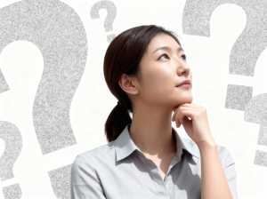 疑問符に囲まれ、思慮深い表情を浮かべたアジア系の若い女性を横顔カメラのアングルから写...。