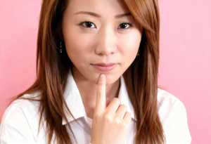 白い襟付きのシャツを着た、長くてまっすぐな茶色の髪の若いアジア人女性の接写。