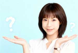 ショートボブのヘアカットをした若いアジア人女性が、両手で何かを差し出しながら視聴者に...。