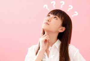 長い茶色の髪と頭上に浮かぶ疑問符に囲まれた思慮深い表情をした若い女性を横顔カメラのア...。