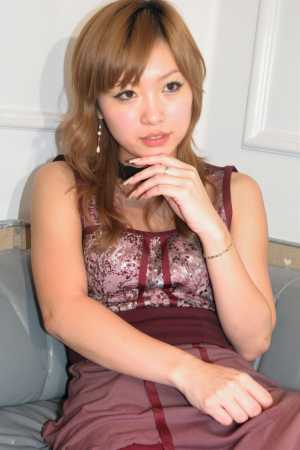 リラックスしたポーズでソファに座り、思慮深い表情で視聴者をまっすぐに見つめている若い...。