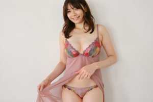 真っ白な壁を背景にフェミニンなランジェリーを着てポーズをとる若い女性を、正面カメラの...。