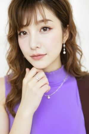 紫色のノースリーブのトップと銀のネックレスを身に着け、思慮深い表情をした若い女性の写...。