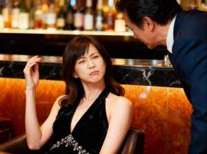 バーでの女性と男性の瞑想的なシーンを横から撮影したフォトリアリスティックな写真。