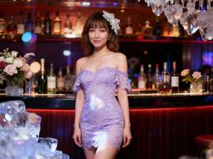 ボトルと花を背景にバーの前に立つ若い女性を正面カメラのアングルから写実的に撮影したもの。