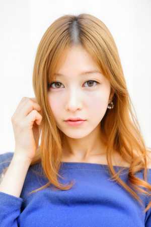 ウェーブのかかった明るい茶色の長い髪と茶色の目をした、青いオフショルダー セーターを...。