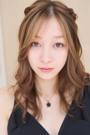 ウェーブのかかった茶色の長い髪を 2 つのお団子にまとめたアジア系の若い女性の接写ポ...。