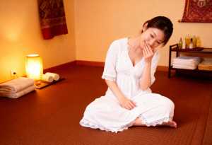 スパのような雰囲気の畳に座る若い女性。