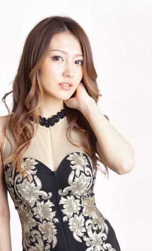 黒と金の花柄のドレスを着てエレガントにポーズをとる若い女性をポートレートカメラの角度...。