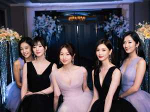 花やスパンコールで飾られた豪華なエントランスの前で、フォーマルな服装に身を包んだアジ...。