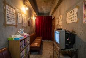 コンクリートの壁と赤いカーテンのある薄暗い部屋。