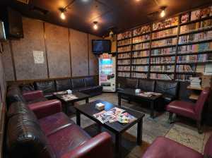 部屋の中央にあるコーヒーテーブルを中心に、黒革張りのソファと赤い革張りの椅子が半円状...。