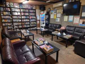 薄暗い部屋に茶色の革張りのソファとテーブルが床に点在している。