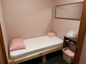 ミニマリスト デザインの小さな寝室を写実的にレンダリングしたもので、木のフレームと白...。