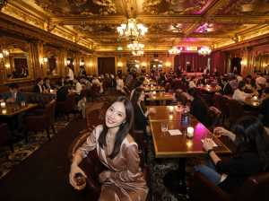 華やかな金枠の天井とシャンデリアのある豪華なレストランを正面から写実的に撮影したもの...。