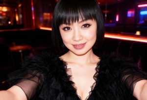 黒い短いボブのヘアカットとドラマチックなアイメイクをした若い女性の自撮り写真。