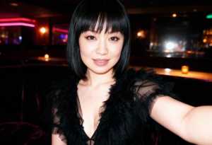 薄暗いバーで自撮りをする若い女性のポートレート。