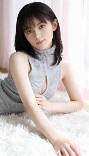 カットアウトのディテールが施されたグレーのノースリーブ タートルネック セーターを着...。