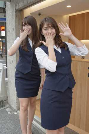 近代的なオフィスビルの前に立つ 2 人の若い女性。