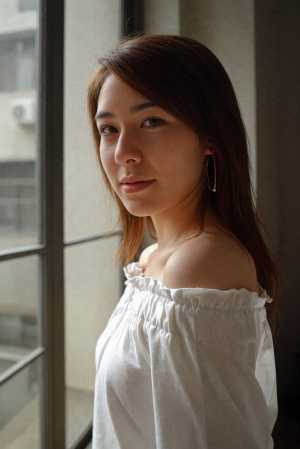 長い茶色の髪を持つ若い女性の写実的なポートレート。