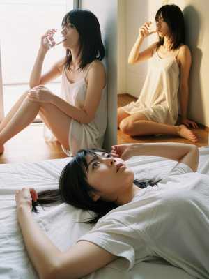 窓から日光が差し込む明るい部屋のベッドに座って、白いナイトガウンを着てリラックスした...。