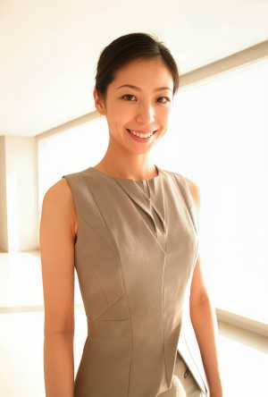 大きな窓のある屋内の明るい部屋に、ノースリーブのベージュのビジネス スーツを着て自信...。