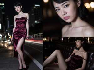 豪華なワインレッドのサテンのドレスを着た女性が夜の街路で自信を持ってポーズをとる、正...。