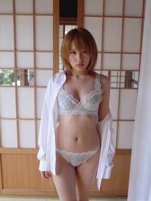 伝統的な和室の襖の前で自信を持って立っている、白いレースのブラジャーとパンティを着て...。