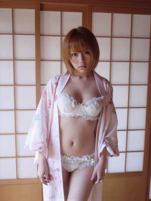 花柄の着物とランジェリーを着て伝統的な和室に立つ若い女性を正面カメラのアングルから写...。