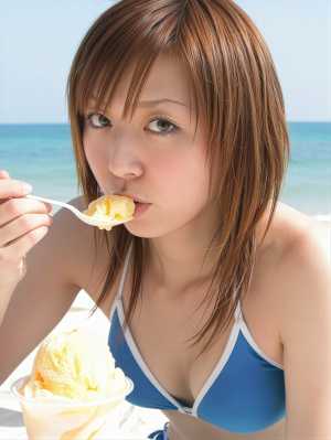 ビーチでアイスクリームを楽しむ若い女性をクローズアップ カメラ アングルから写実的に...。