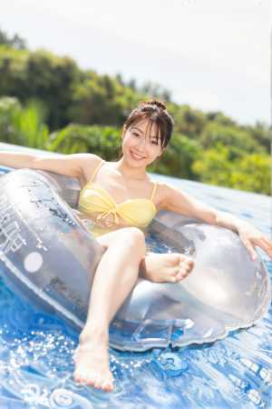 黄色のビキニを着て、画像中央の浮き輪に座って、プールでリラックスしている若い女性を正...。