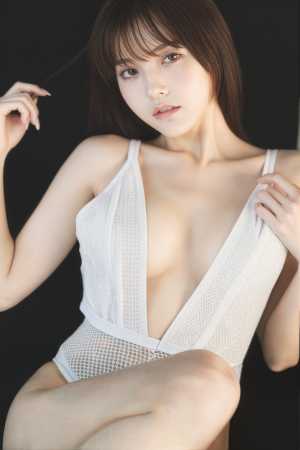 暗い背景に露出度の高い白い衣装を着てポーズをとる若い女性を、クローズアップ カメラ ...。