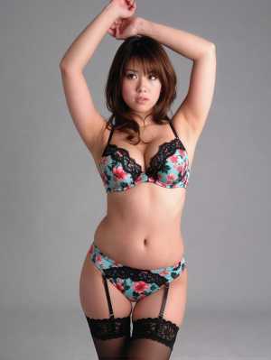 花柄のランジェリーセットを着て、腕を上げて自信満々にポーズをとるモデルを正面カメラの...。