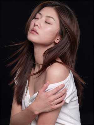 黒い背景のスタジオ設定で、白いオフショルダーのトップスを着た、長い茶色の髪をなびかせ...。