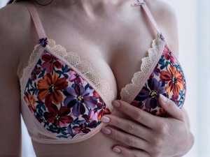 花柄のブラジャーを着けた女性の上半身を正面から、胸を中心にクローズアップした写真です。
