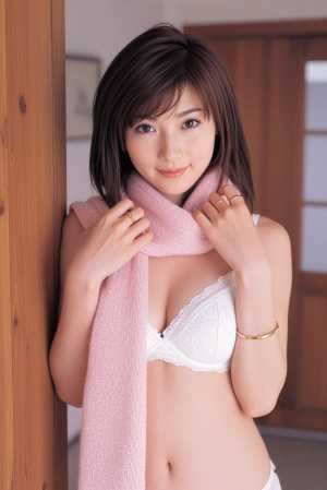 白いブラジャーとピンクのスカーフを身に着け、居心地の良い屋内環境でポーズをとる若い女...。