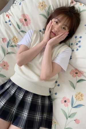 ベッドで白のセーターを着た美女