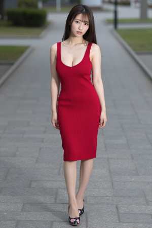 赤のドレス姿で公園に佇む女性