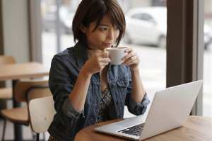 カフェでリラックスして仕事する女性