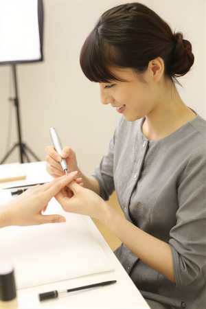 電動ファイルで爪を整えるネイリスト