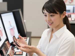 コスメカウンターでチークを選ぶ女性
