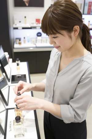 コスメカウンターで香水を試す女性
