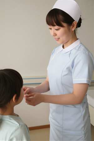 小児病棟で子供にシールを渡す看護師