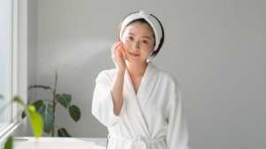 バスルームでフェイシャルミストを使う女性