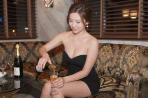 クラブのソファで客に寄り添うドレスの嬢