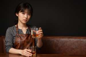 ウイスキーバーでボトルを推奨する女性