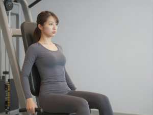 ジムでレッグプレスを行う女性