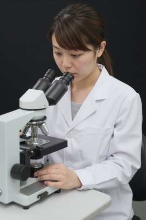 顕微鏡で作業する検査技師