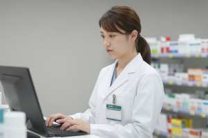 薬局でPC作業する薬剤師